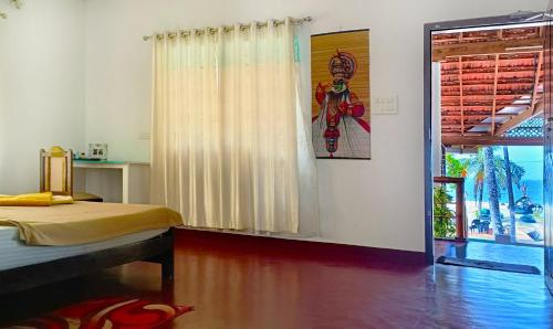 a bedroom with a bed and a window in a room at Marari Praise Beachfront Homestay in Mararikulam