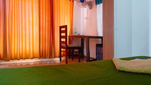 a bedroom with a bed and a desk and a chair at Marari Praise Beachfront Homestay in Mararikulam