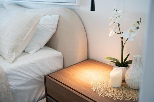 a bed with a wooden table with a vase on a nightstand with at Seaside Cove Studio-Completely Renovated! in Fajardo