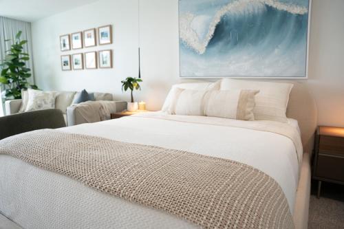 a bedroom with a large white bed and a couch at Seaside Cove Studio-Completely Renovated! in Fajardo
