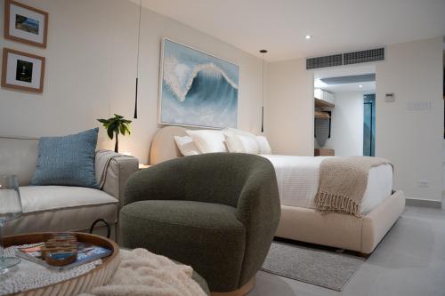 a bedroom with a bed and a couch and a chair at Seaside Cove Studio-Completely Renovated! in Fajardo