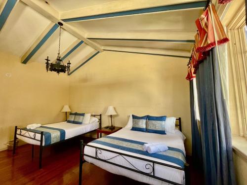 a bedroom with two beds and a chandelier at Young Mansion Steps To The Beach in Hollywood