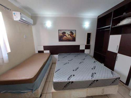 a bedroom with two beds and a painting on the wall at diRoma Fiori - Apartamentos JN in Caldas Novas