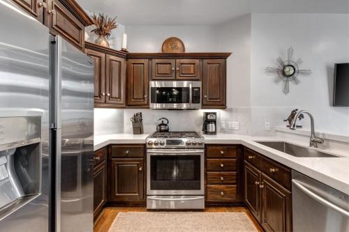 a kitchen with wooden cabinets and stainless steel appliances at LIFT LODGE 102 condo in Park City