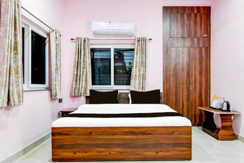 ラーンチーにあるHotel O Ritushreeのベッドと窓のある寝室