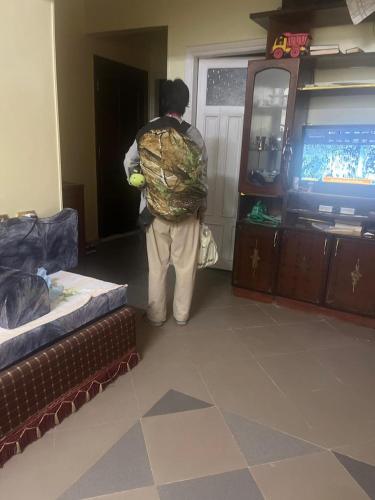 a person standing in a living room watching a television at Alara Hostel ' Only girls ' in Naj‘ al Maḩaţţah