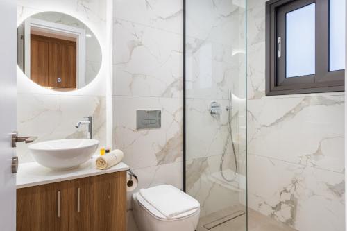 a bathroom with a toilet and a sink and a shower at Santa Barbara Sea front resort and spa in Polis Chrysochous