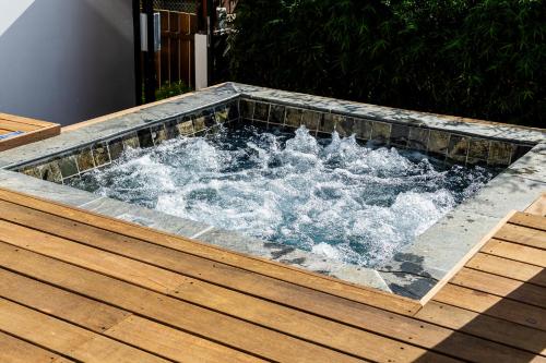 a hot tub on a wooden deck with water at Les Horizons de Grand Fond in Saint-Gilles les Bains