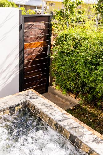 a wooden door leading into a pool of water at Les Horizons de Grand Fond in Saint-Gilles les Bains