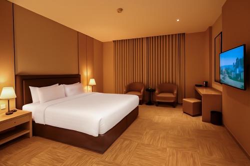 a hotel room with a bed and a flat screen tv at Towlan Alrayan in Quai