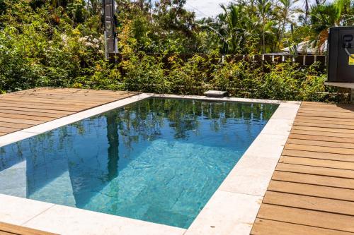 a small swimming pool with a wooden deck at Les Horizons de Grand Fond in Saint-Gilles les Bains