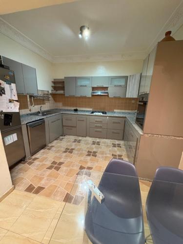 an empty kitchen with purple chairs in a room at Sweet home in Marrakech