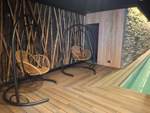 two chairs in a room with a swimming pool at Ayres de Calafate in El Calafate