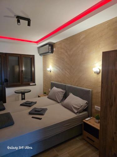 a bedroom with a bed with a red stripe on it at Vila Mara in Gornja Toplica