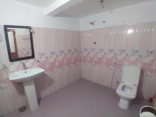 Un baño con lavabo, inodoro y espejo. en Day holiday villa, en Trincomalee