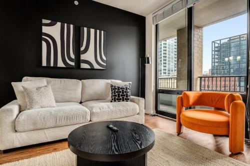 a living room with a couch and a table and a chair at Boulevard Stays 5 mins to Riverwalk & Mag Mile 03 in Chicago