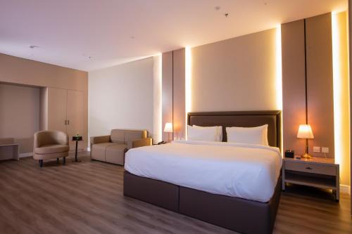 a hotel room with a large bed and a chair at Towlan Alrayan in Quai