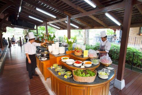 twee koks staan in een keuken eten te bereiden bij Patravana Resort in Phayayen