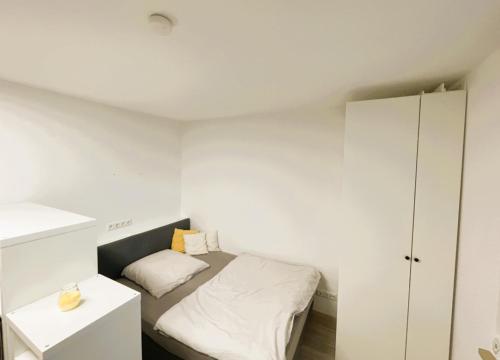 a small bedroom with a bed and a cabinet at Appartment Schwabenblick in Augsburg
