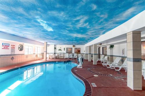 a pool in a hotel room with a ceiling covered in clouds at Motel 6-Oklahoma City, OK in Oklahoma City