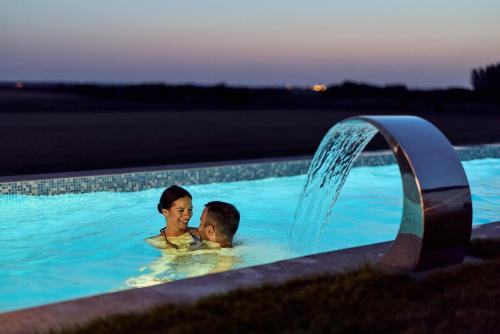 a man and a woman in a swimming pool at Spa and Wellness Pannonia in Elemir