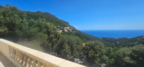 a view of a mountain with the ocean in the background at Appartement indépendant vue mer in Alzetu