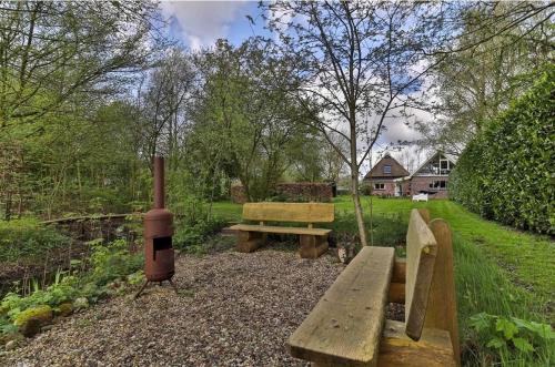 a park with a bench and a wood stove at Nieuwbouw appartement in groene oase in Boelenslaan