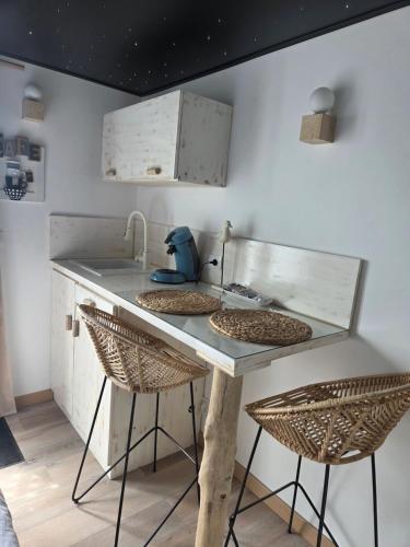 a kitchen with a sink and two stools at Le studi'eau in Ferques