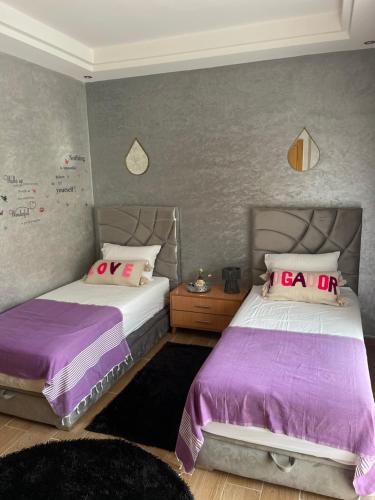 two beds sitting next to each other in a bedroom at Superbe duplex de luxe neuf et spacieux avec vue sur l'océan دوبلكس جديد فاخر مع إطلالة على المحيط in Agadir