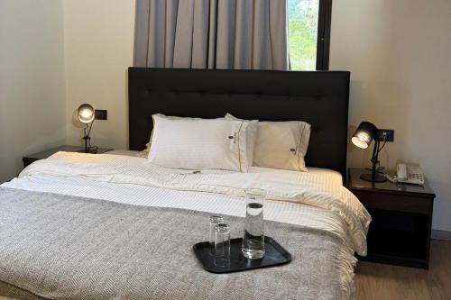 a bed with a tray with two glasses on it at Marbella Hotel in Jounieh