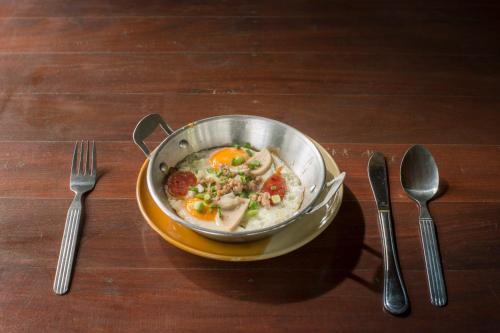 een kom soep op een bord naast twee vorken bij Patravana Resort in Phayayen