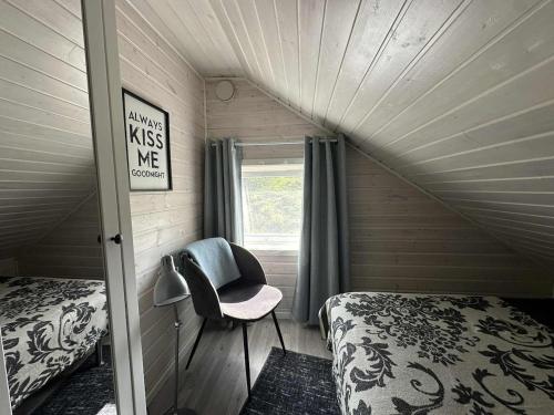 una camera da letto con un letto e una sedia in una stanza di Discover the ultimate aurora escape with a cozy outdoor sauna and hot tub a Karlsøy