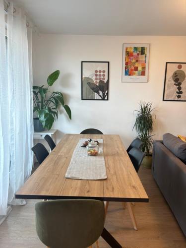 a dining room with a wooden table and chairs at Agréable 3 pièces - 8P - Parking - Séjour idéal Paris Proche Gare in La Courneuve