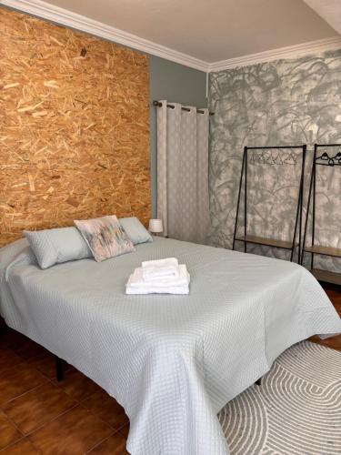 a bedroom with a bed with two towels on it at Casa de Campos AL in Angra do Heroísmo