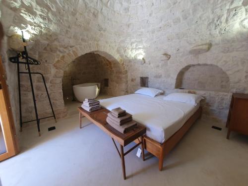 a bedroom with a bed and a table with books at Trullo Antonelli in Antonelli