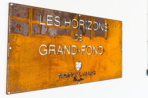 an old rusty sign with the wordsles horizons de grand fond at Les Horizons de Grand Fond in Saint-Gilles les Bains