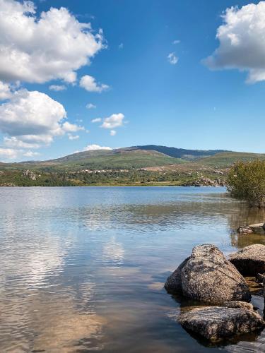 a large lake with rocks in the water at Casa As Fontes in Porqueirós