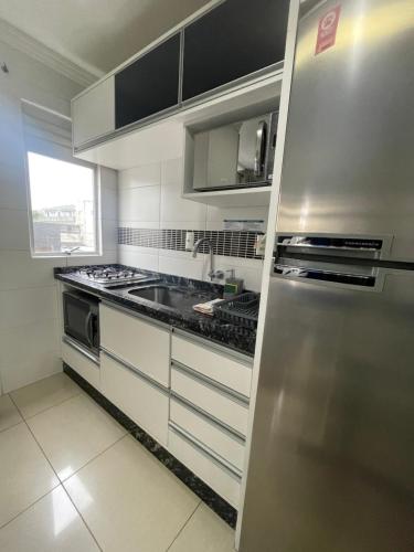 a kitchen with a stainless steel refrigerator and a sink at Residencial Nicole in Florianópolis