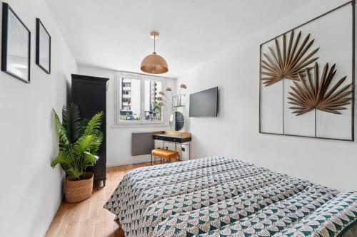 Un dormitorio con una cama y un escritorio. en Appartement Design Porte de Paris avec parking, en Sèvres