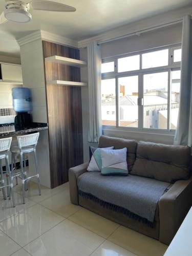 a living room with a couch in front of a window at Residencial Nicole in Florianópolis