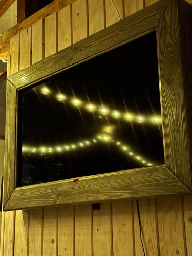 a window with lights on a wooden wall at Stenata LightWill in Banya
