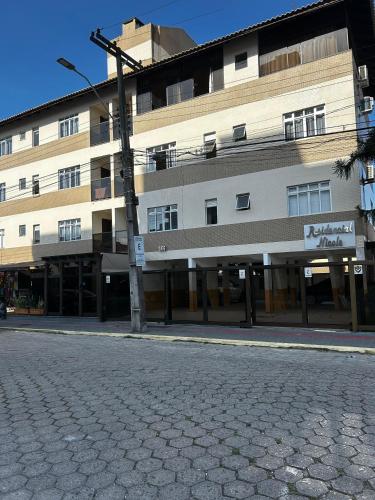 an empty street in front of a large building at Residencial Nicole in Florianópolis
