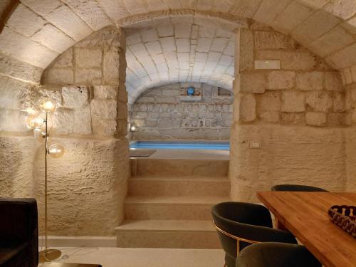 a stone archway with stairs in a room at La Dimora dei Sapienti Luxury House in Melendugno