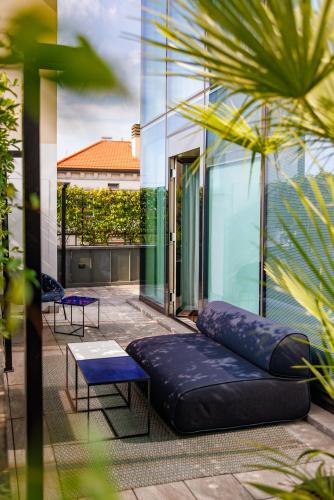 a balcony with a couch and a table and a building at Casa Baglioni Milan - The Leading Hotels of the World in Milan