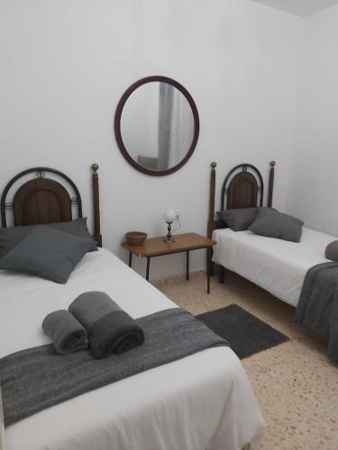 a bedroom with two beds and a mirror on the wall at Casa La Barricoza 