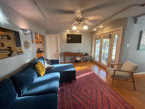 een woonkamer met een blauwe bank en een rood tapijt bij Cozy Beach Bungalow- Happynest in Long Beach