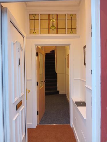 a hallway with stairs and stained glass windows at Double Ensuite - City centre homestay - Peterill Room - in Carlisle