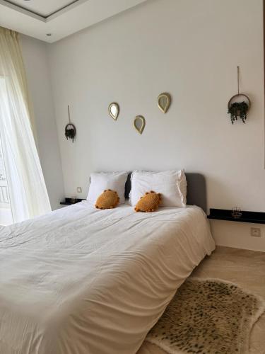 a bedroom with a large white bed with two pillows at Shems Bouznika Residence Central & Cozy 2 Bedroom Apartment with Pool Bouznika in Bouznika