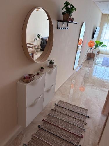 a hallway with a circular mirror and a rug at Shems Bouznika Residence Central & Cozy 2 Bedroom Apartment with Pool Bouznika in Bouznika
