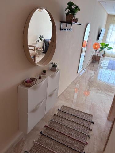 a hallway with a circular mirror and a rug at Shems Bouznika Residence Central & Cozy 2 Bedroom Apartment with Pool Bouznika in Bouznika